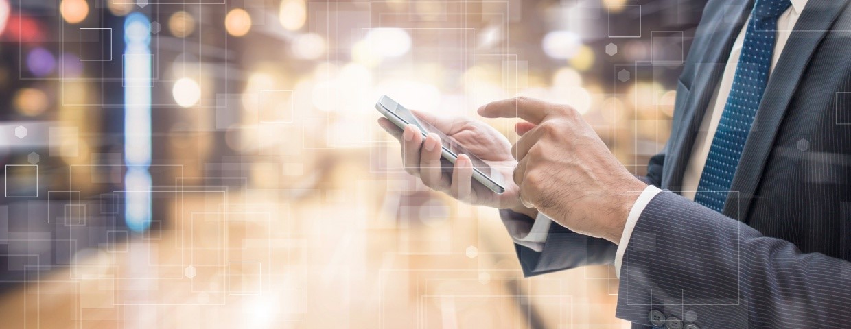 Uomo d'affari in un datacenter con uno smartphone nelle sue mani